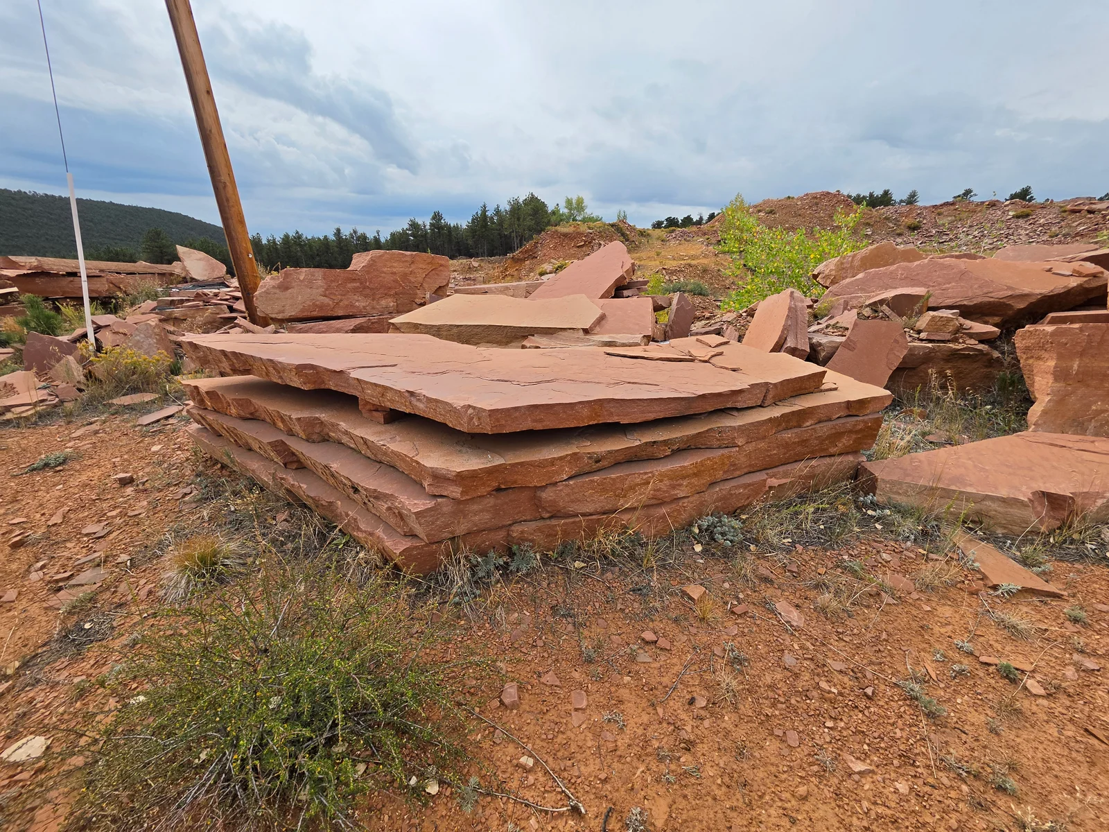 Thinner natural flagstone slabs stacked at the quarry